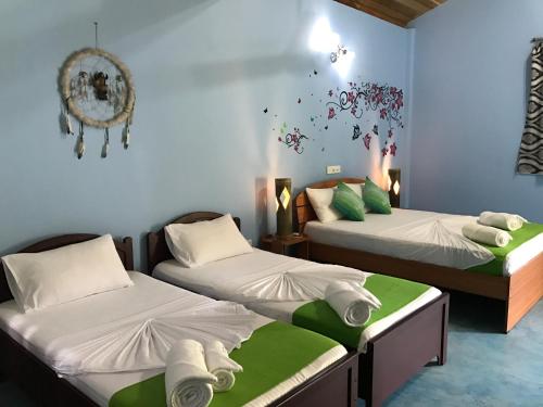 a room with two beds and a wall at Shell Resort in Arugam Bay