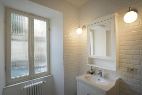 a bathroom with a sink and a mirror and a window at Le camere di Sementis in Pietrasanta