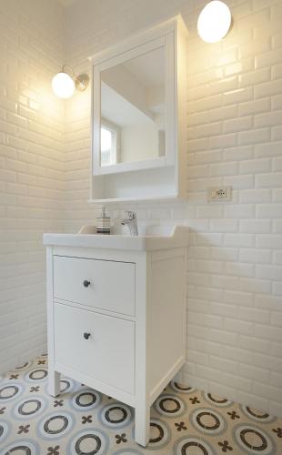 a white bathroom with a sink and a mirror at Le camere di Sementis in Pietrasanta
