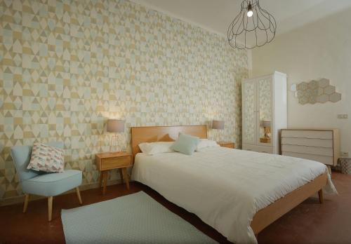 皮耶特拉桑塔的住宿－Le camere di Sementis，卧室配有白色的床和蓝色椅子