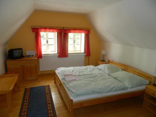 a bedroom with a bed and two windows at Hospoda na Peci in Pec pod Sněžkou