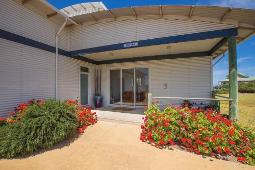 a house with flowers in front of it at Cottages for Couples in Port Fairy