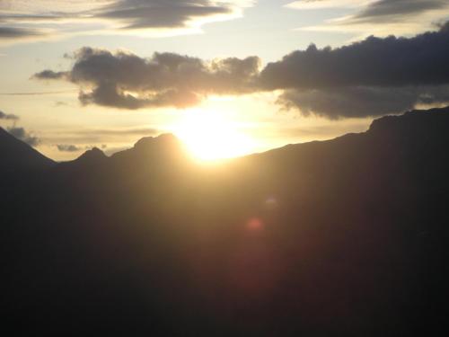 a sunset over the mountains with the sun in the sky at Hotel Garni Lamm in Nauders