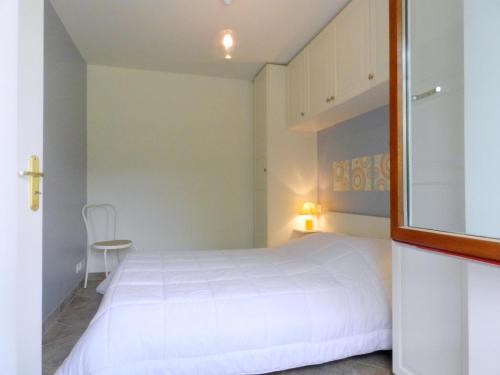 a bedroom with a white bed and a mirror at Gîte les Platanes in Sainte-Hélène-du-Lac