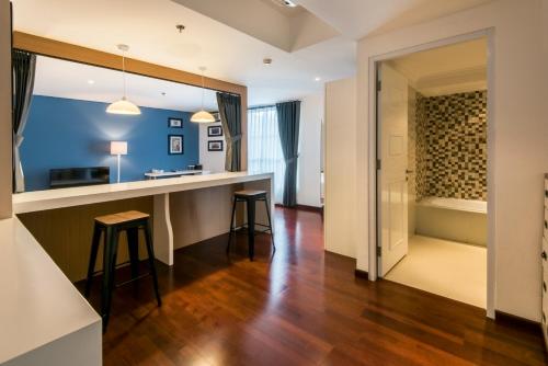 a kitchen with a bar and a walk in shower at Yan's House Hotel in Kuta