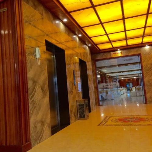 a lobby with a large stone wall and a glass door at Vinh Plaza Hotel in Vinh