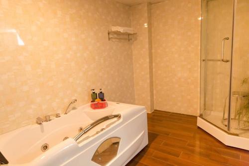 a bathroom with a white tub and a shower at Vinh Plaza Hotel in Vinh