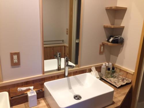 a bathroom with a white sink and a mirror at Kakimotoya in Sango