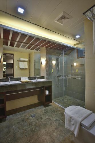 a bathroom with a glass shower and a sink at Coron Soleil Garden Resort in Coron
