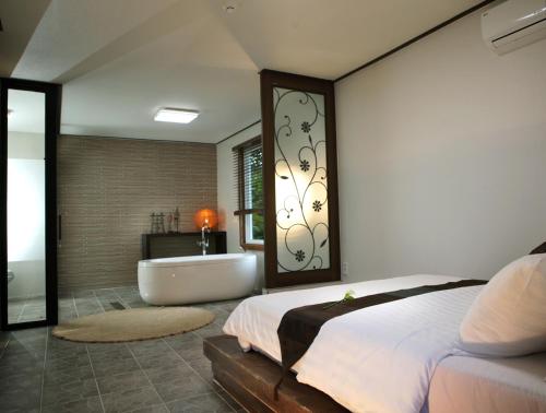 Thai Story في سيوجويبو: غرفة نوم مع حوض وسرير وحمام