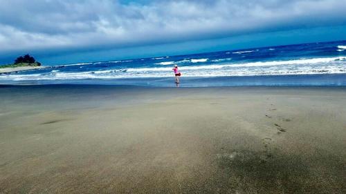a person standing on the beach looking at the ocean at Tamowan in Donghe