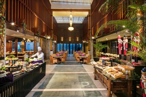 a restaurant with tables and a chef preparing food at Wyndham Garden Suzhou in Suzhou