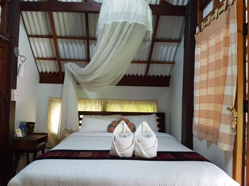 - une chambre dotée d'un lit avec des chaussures blanches dans l'établissement Niwas Ayutthaya, à Phra Nakhon Si Ayutthaya