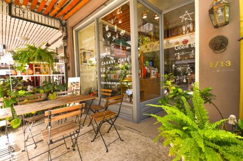 un magasin avec un banc et une table devant lui dans l'établissement Good Day Hostel, à Bangkok