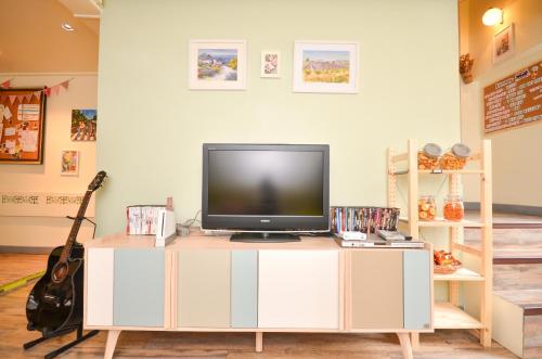 a tv on a white cabinet in a room at Good Day Hostel in Bangkok