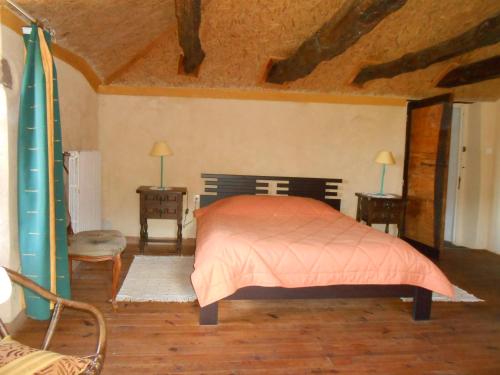 a bedroom with a bed and two tables and a surfboard at Chambre d'hôtes des Monts in Saint-Izaire