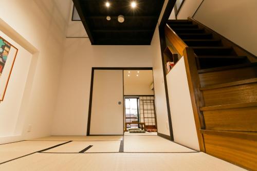 an empty hallway with a staircase in a house at Hashiba-an in Kanazawa