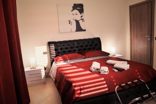 1 dormitorio con 1 cama con sábanas rojas y toallas en L'Airone Country House en SantʼElia Fiumerapido
