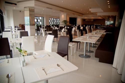 a dining room with white tables and chairs at Iyarin @ Tuk Chang Hotel in Bangkok