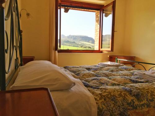 Bett in einem Zimmer mit Fenster in der Unterkunft Agriturismo Furfullanu in Nurallào