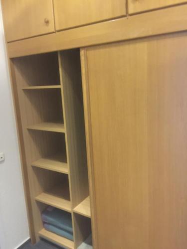 a closet with a wooden cabinet with shelves at Pension KRUSE in Büsum