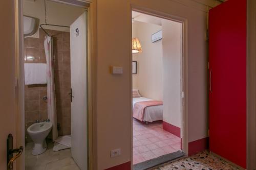 um quarto com uma casa de banho com uma cama e um WC em Hotel d'Azeglio Firenze em Florença