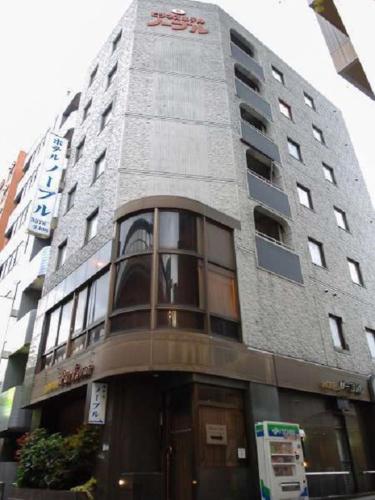 wysoki budynek z znakiem na boku w obiekcie Nishishinjuku Green Hotel w Tokio