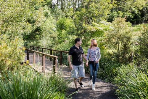 a man and a woman walking on a bridge at Spicers Tamarind Retreat in Maleny