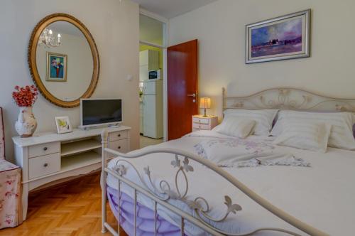 Un dormitorio con una cama blanca y un espejo. en Apartments Zoran, en Split