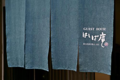a pair of blue curtains with a guest house sign on them at Hashiba-an in Kanazawa
