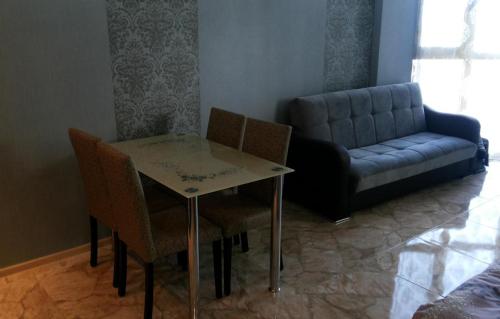 sala de estar con mesa, sillas y sofá en Kobaladze 4 Apartment en Batumi