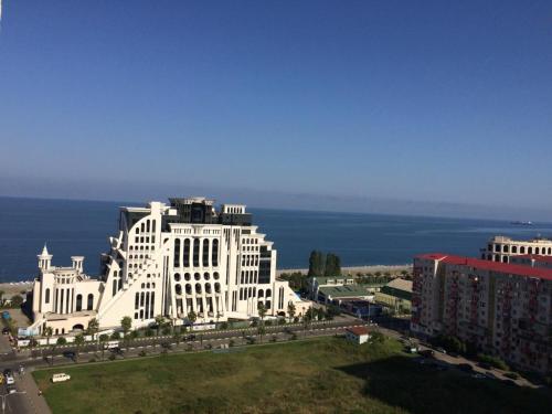 un gran edificio blanco con el océano en el fondo en Kobaladze 4 Apartment en Batumi
