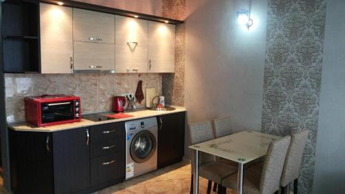 cocina con lavadora y mesa en Kobaladze 4 Apartment en Batumi
