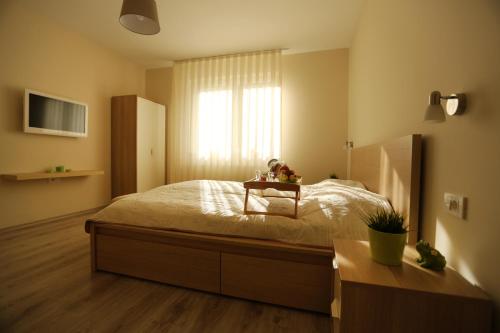 a bedroom with a bed with a table on it at The Green Apartments in Magarevo