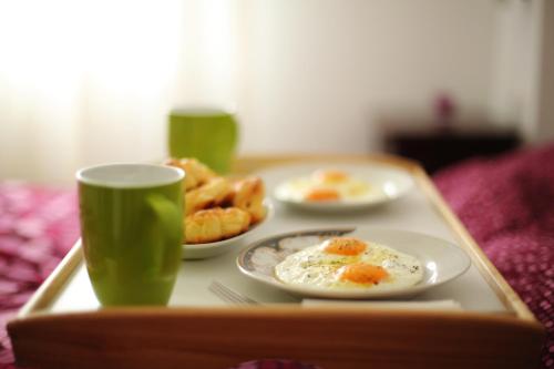 a tray with two plates of food and two cups at The Green Apartments in Magarevo