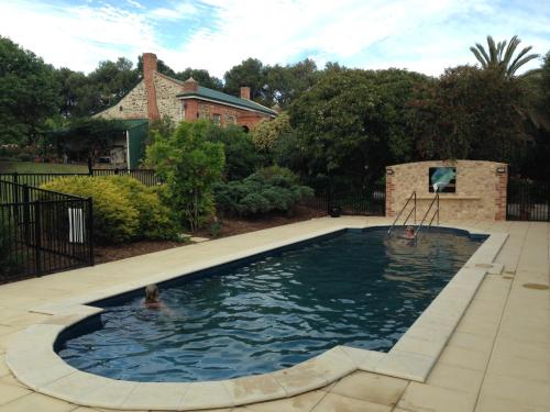 a pool in a yard with a person in the water at The Garden Cottage at The Olives in Yankalilla