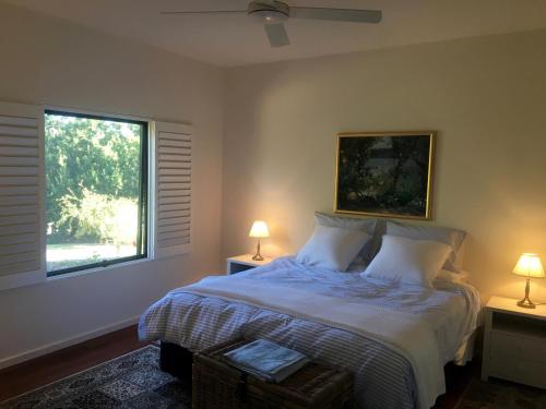 une chambre avec un lit avec deux lampes et une fenêtre dans l'établissement The Garden Cottage at The Olives, à Yankalilla