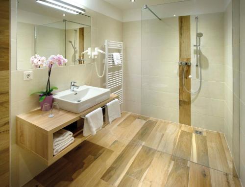 a bathroom with a sink and a shower at Hotel Aberseehof in Sankt Gilgen