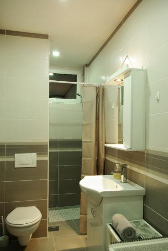 a bathroom with a white sink and a toilet at Square Studio Apartment in Niš