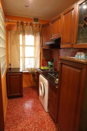 トリノにあるAppartamento Katiaのキッチン(木製キャビネット、洗濯機、乾燥機付)
