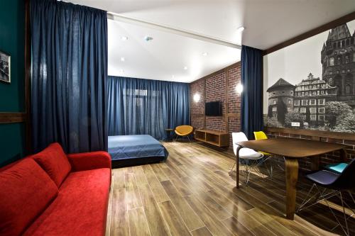 スヴェトロゴルスクにあるOld City Boutique Apartmentsのソファ、ベッド、テーブルが備わる客室です。