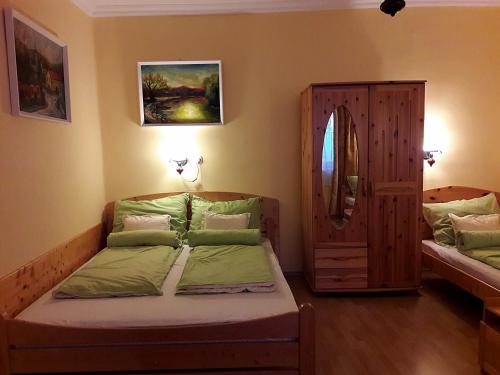 a small bedroom with two beds and a mirror at Viktor Vendégház in Tokaj