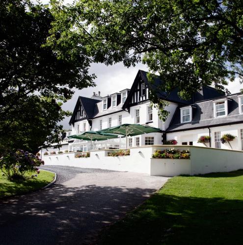 a large white building with black roof at Ilsington Country House Hotel & Spa in Ilsington