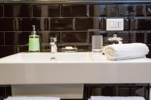 y baño con lavabo y toallas. en App Condotti Luxury Apartment In Rome, en Roma