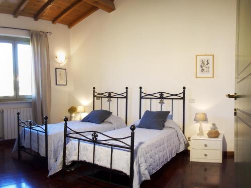 1 Schlafzimmer mit 2 Betten und einem Fenster in der Unterkunft Appartamenti I Cortivi in Costermano sul Garda