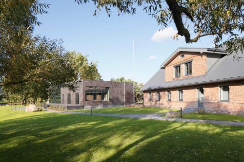 an image of a building with a grass yard at Zoltners Hotel in Tērvete