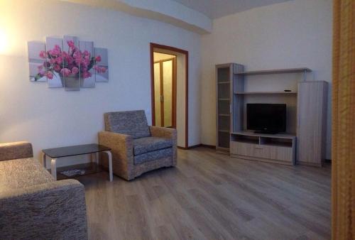 a living room with a couch and a chair and a television at Apartament na Vielikoy in Velikiy Novgorod