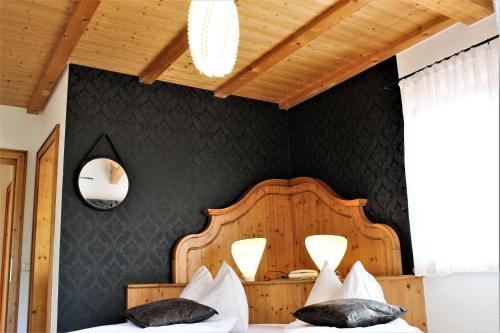 a bedroom with a bed with a wooden headboard at Gartenresidence Stephanie by Hotel Rotwand in Laives