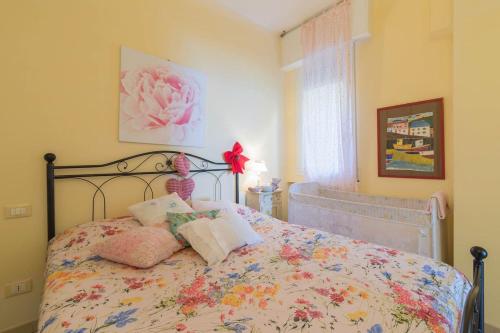 a bedroom with a bed with a floral bedspread at La Casa di Pepe in Pietra Ligure