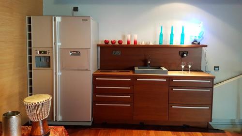 uma cozinha com um frigorífico de aço inoxidável e armários de madeira em Theater and Beach Apartment em Tampere